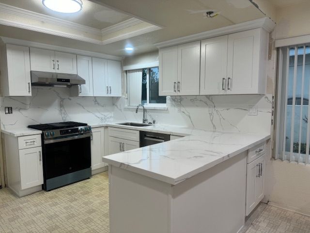 Modern white kitchen with marble countertops, cabinets, and appliances.