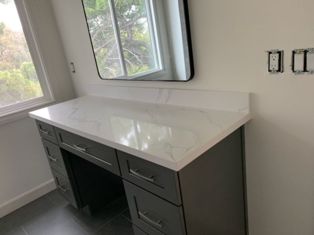 Bathroom vanity with a white countertop and a mirror