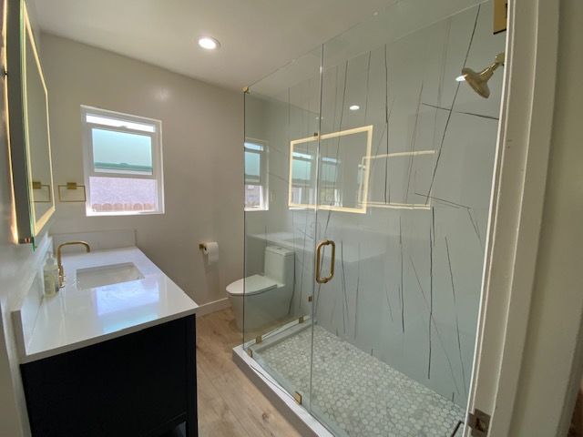 Walk-in shower, sink, toilet, and mirror