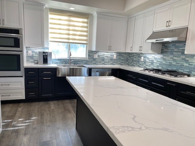 A kitchen with black cabinets and white countertops