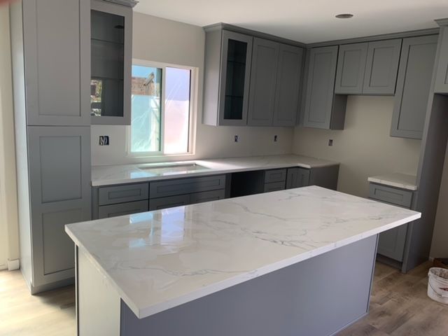 Kitchen with gray cabinets and white countertops