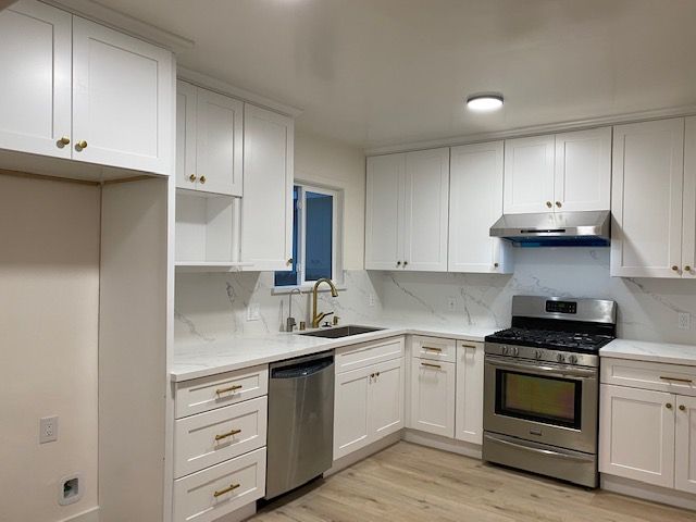A kitchen with white cabinets and stainless steel appliances