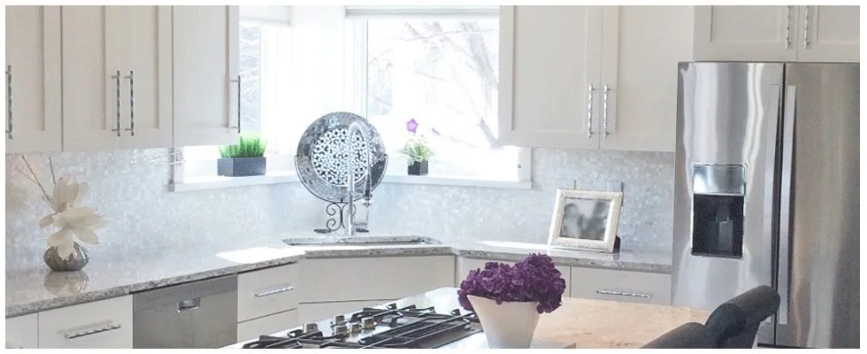 A kitchen with white cabinets and stainless steel appliances