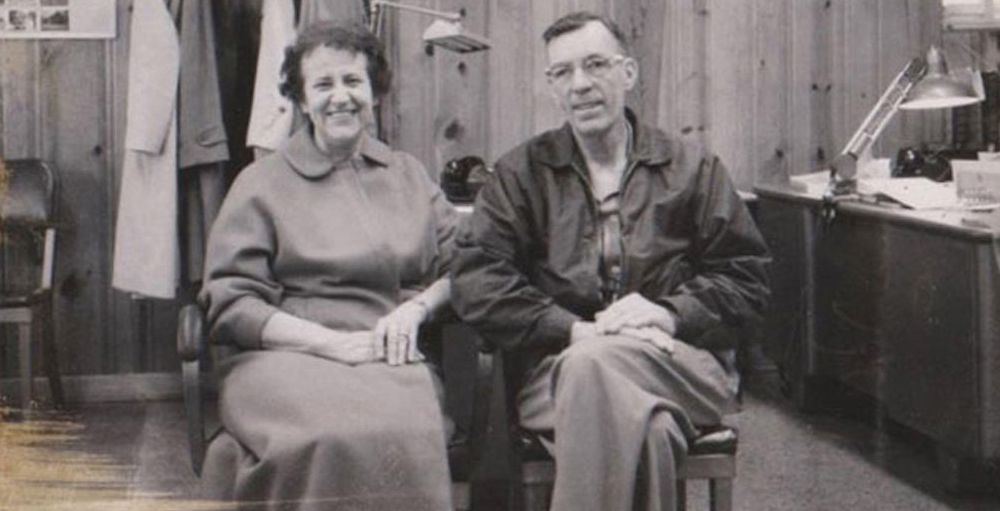 A man and a woman are sitting next to each other in a black and white photo.
