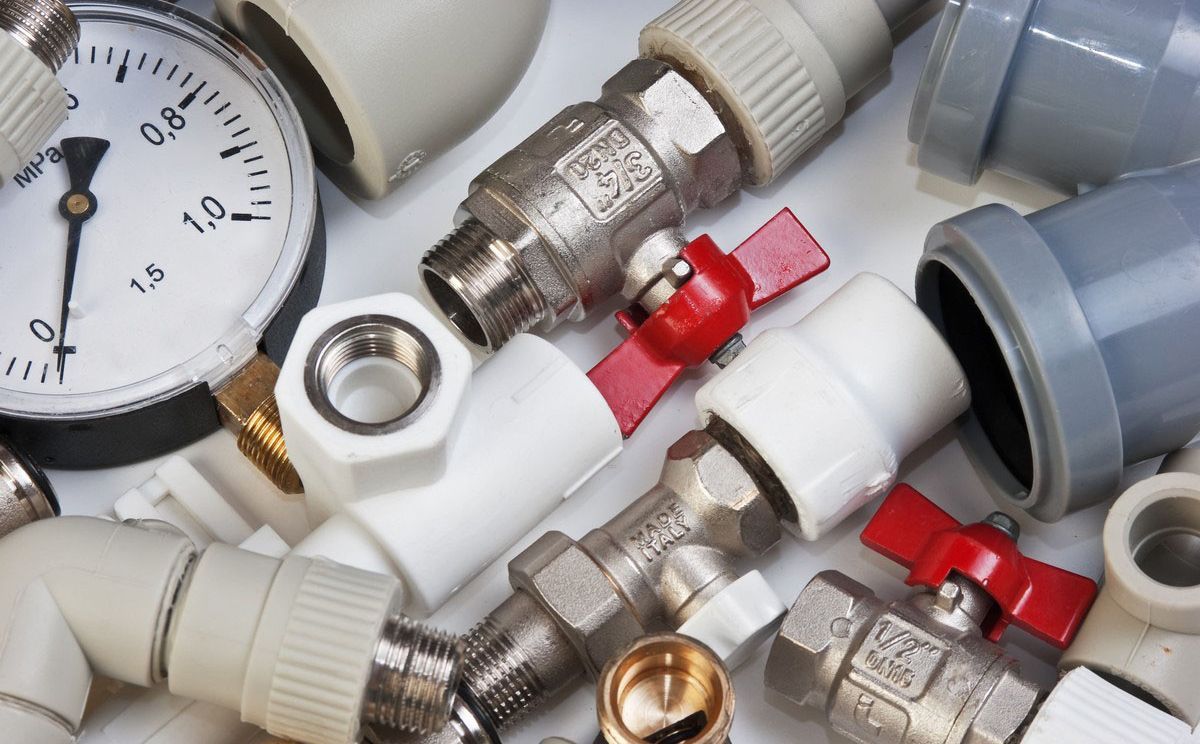 A bunch of plumbing parts including valves and a pressure gauge