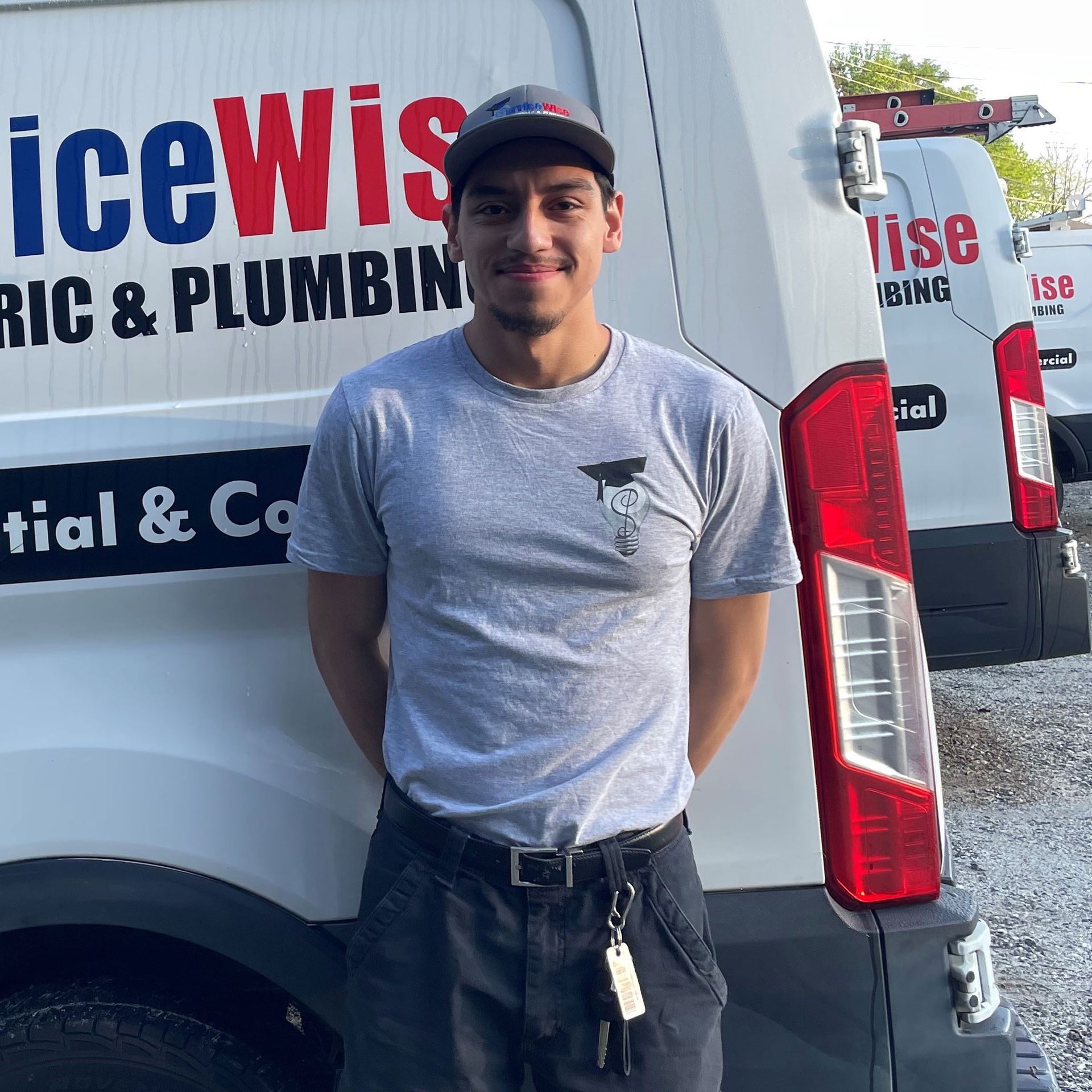 Man in gray shirt stands in front of a white van with