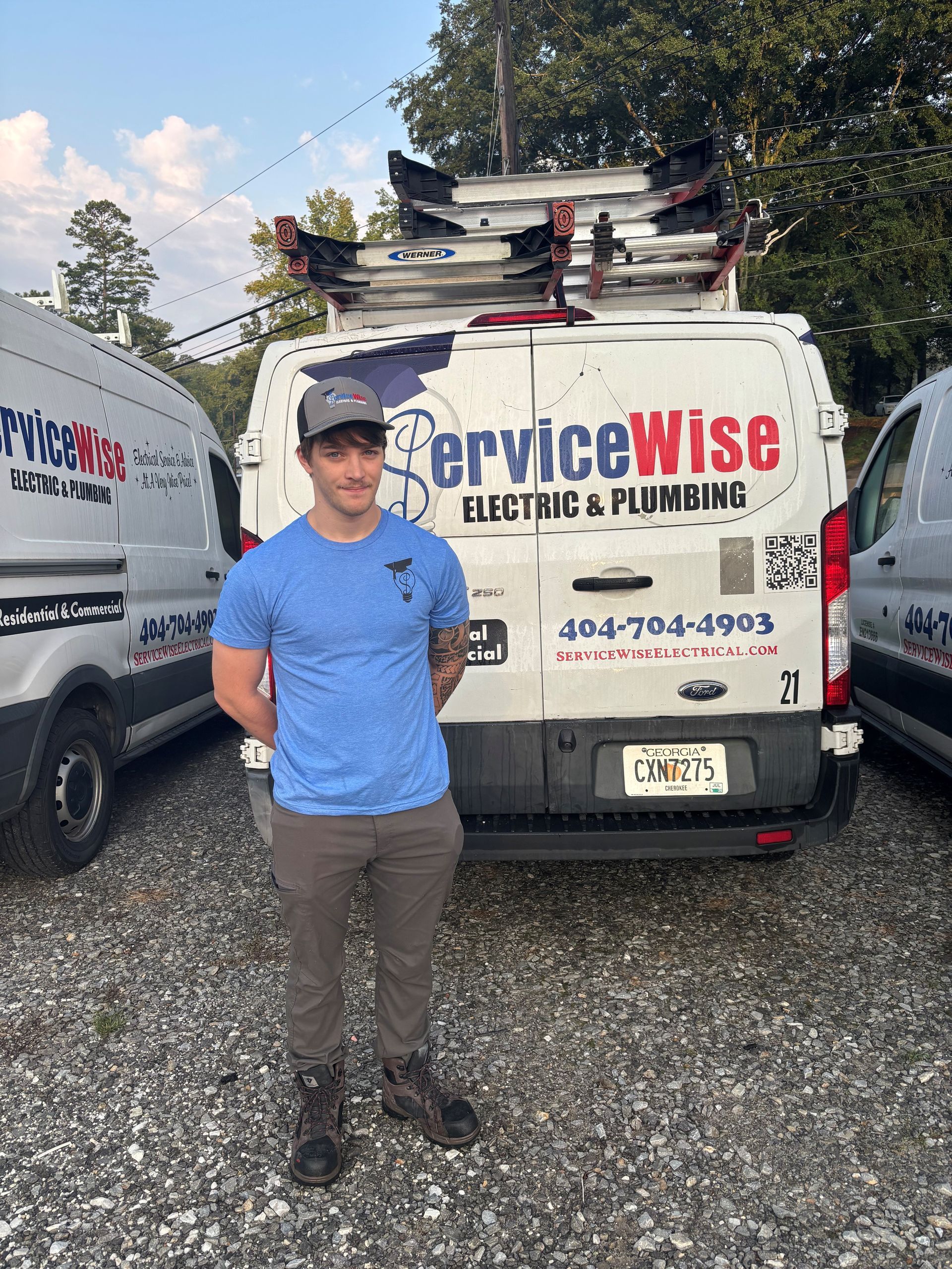 Man standing in front of ServiceWise van, wearing a blue shirt and gray pants.
