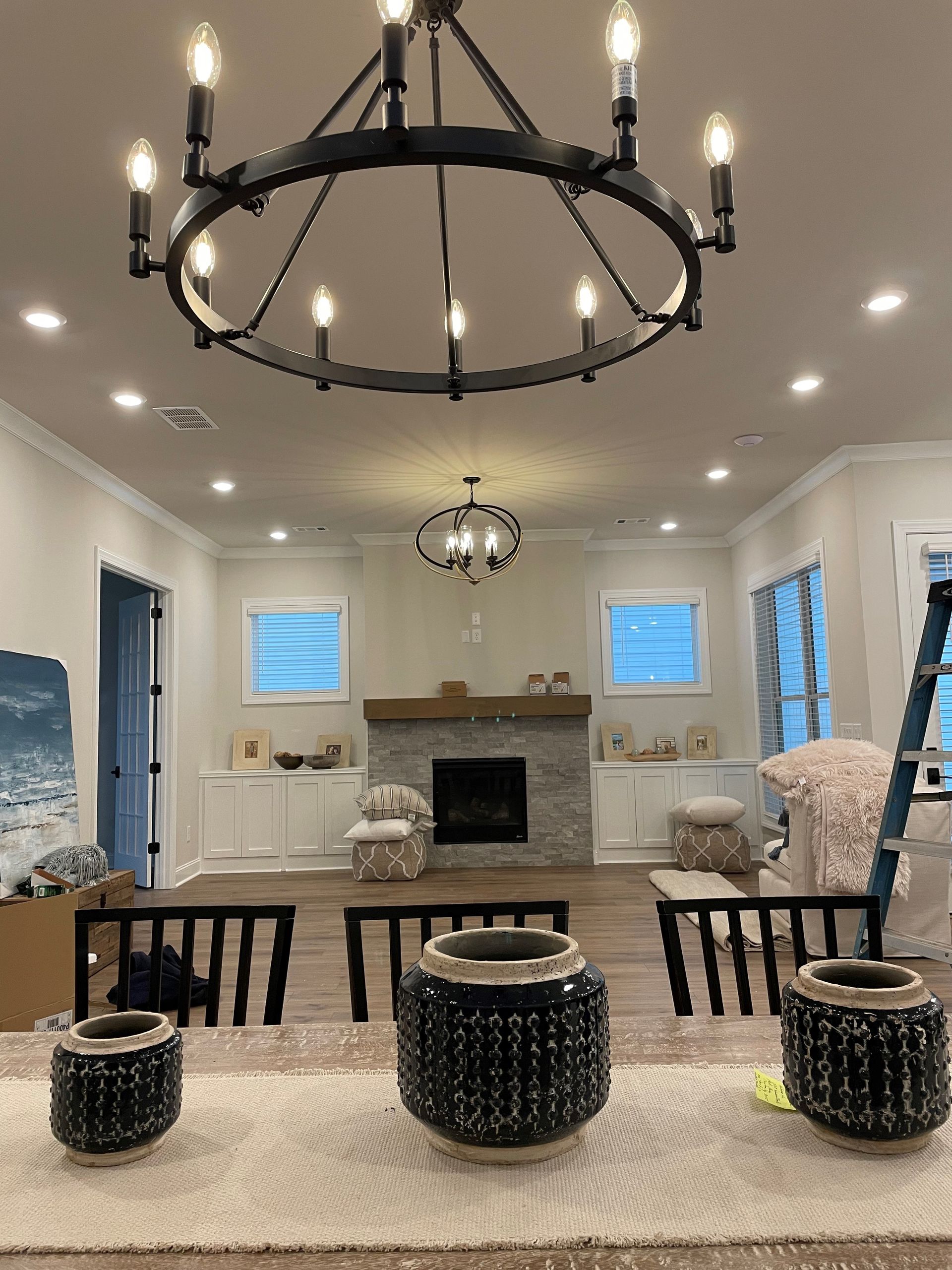 Dining room with chandelier, fireplace, and table with decorative vases.