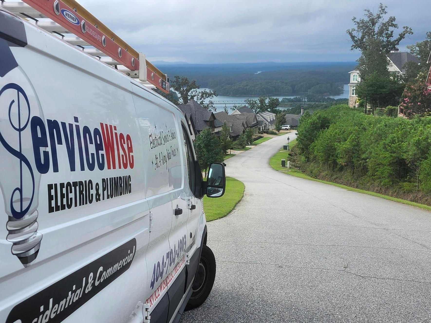 ServiceWise van on a residential street with a view of a lake and houses.