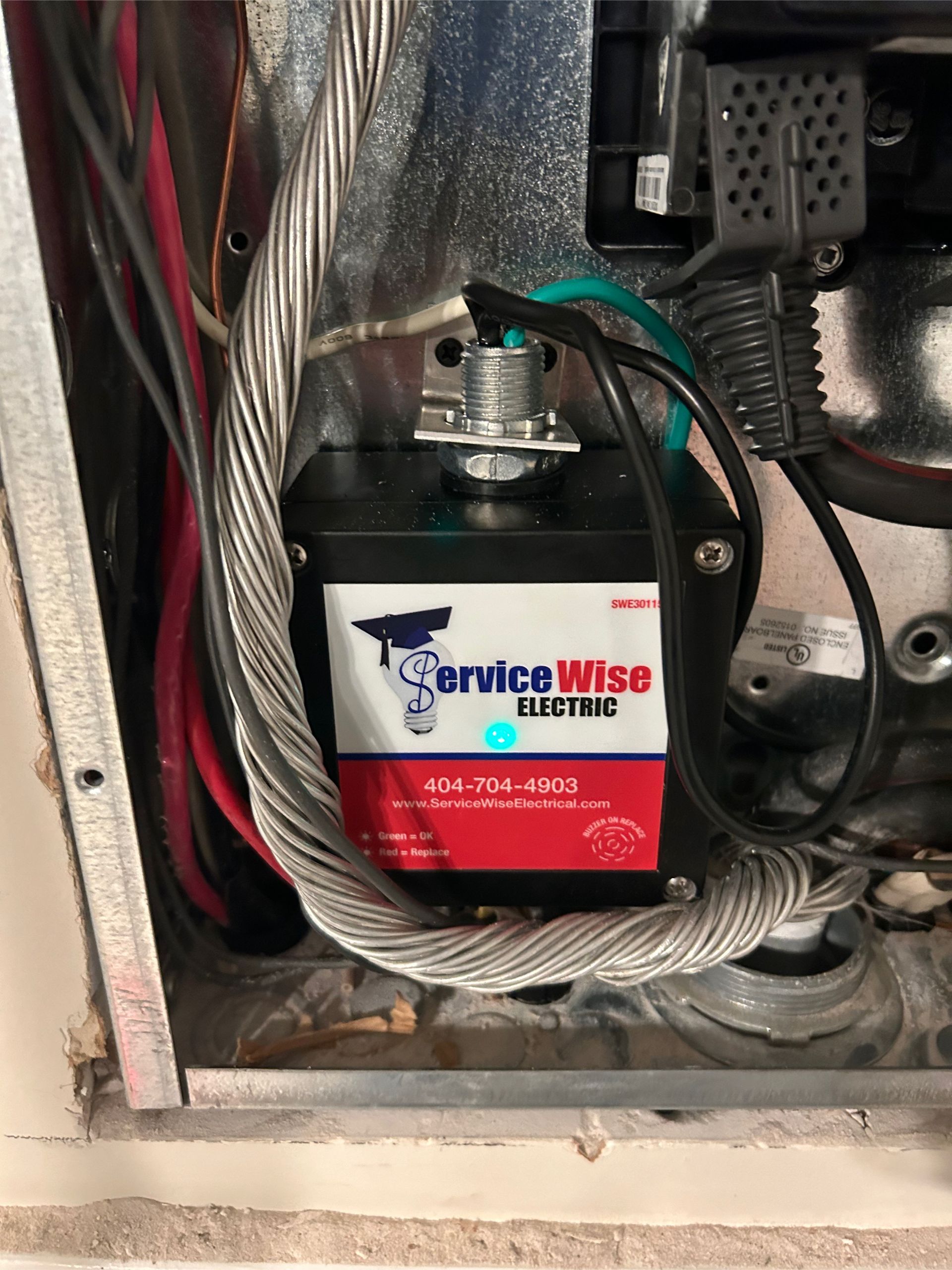 Electrical panel with a black device labeled 