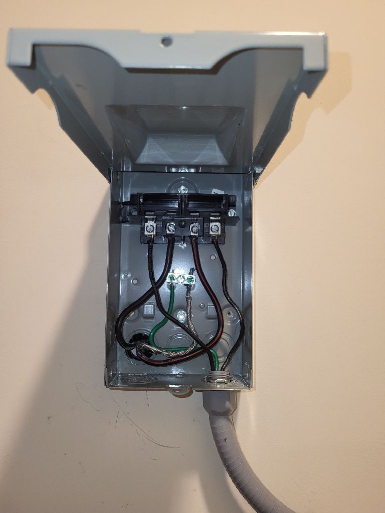 Open electrical junction box with wiring on a wall.