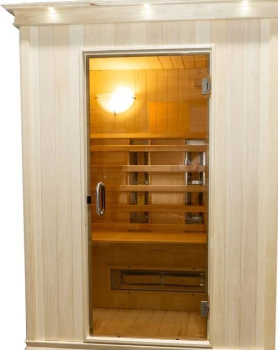 Wooden sauna with glass door, light inside.