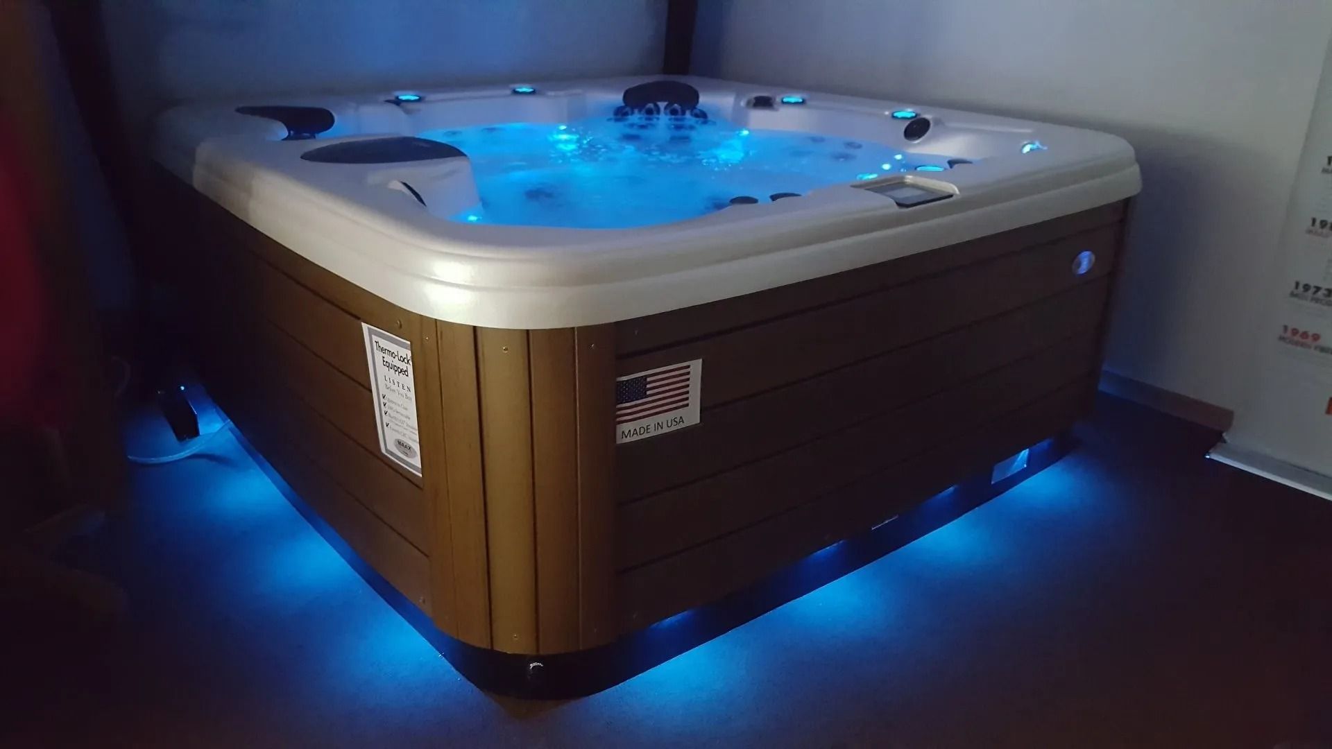 Hot tub with blue water and lights; brown exterior, white trim.