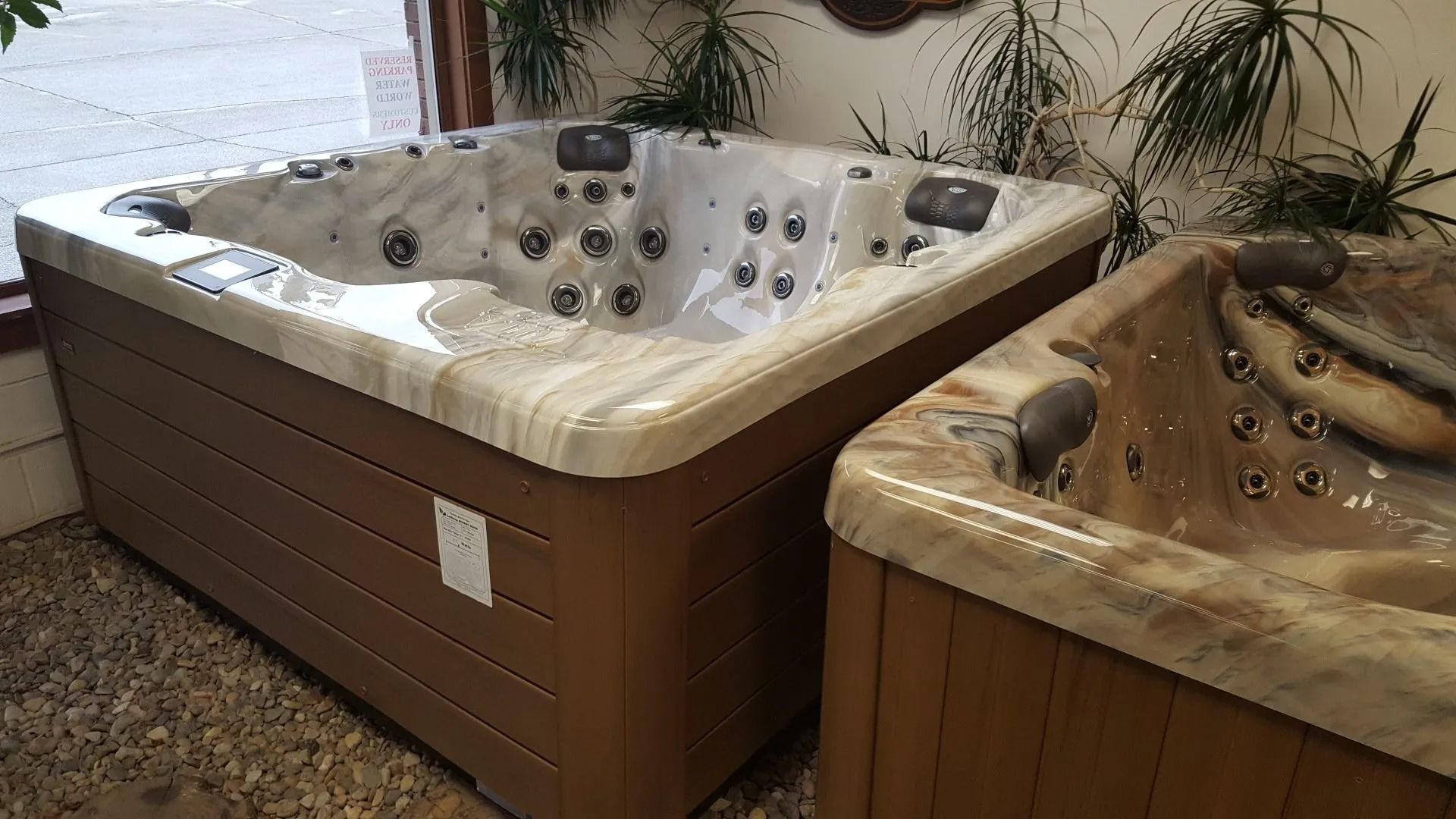 Two brown hot tubs with marble-like edges on display indoors.