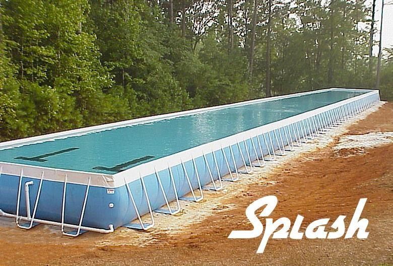 Rectangular above-ground pool on a brown dirt surface, surrounded by trees. Blue pool with the word 