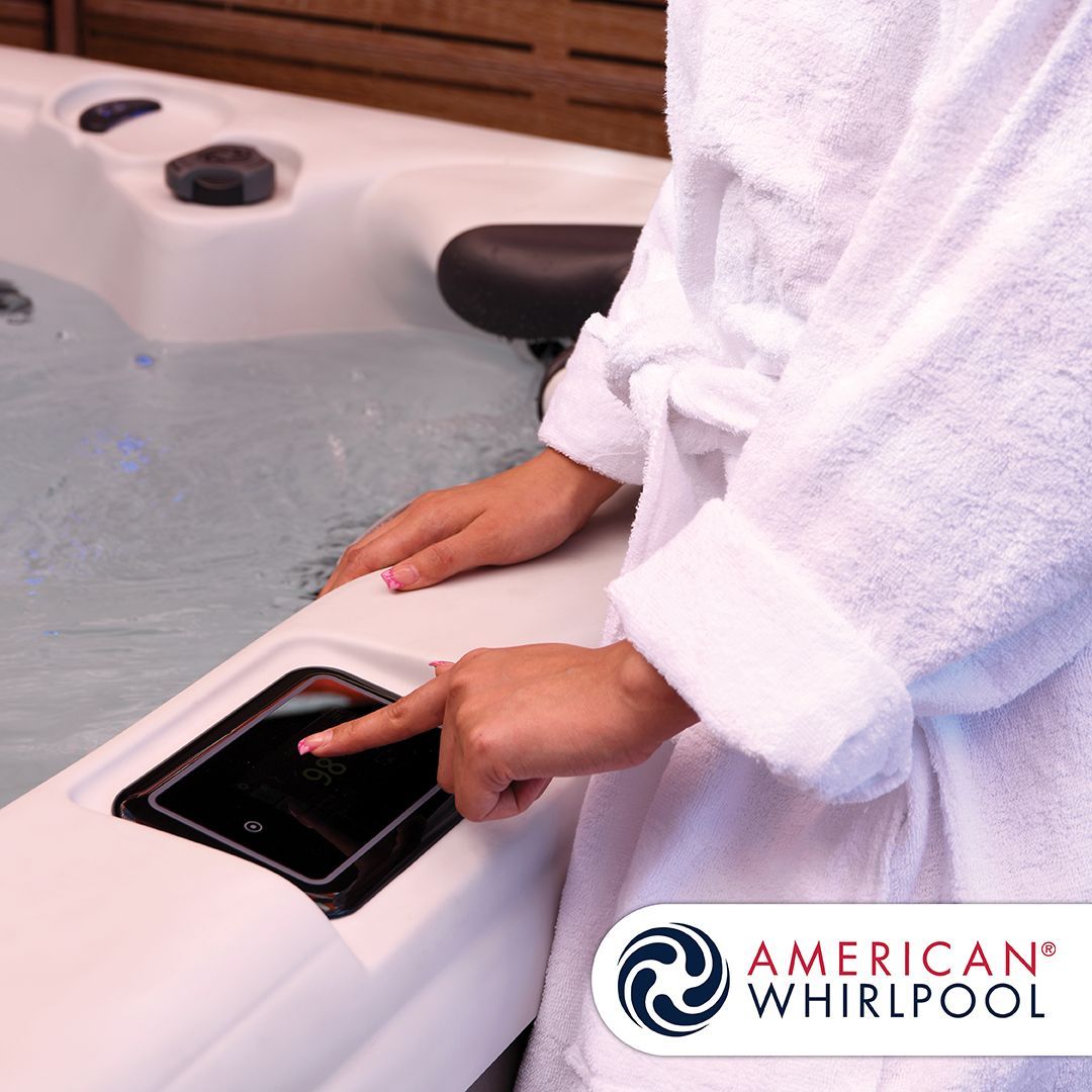Person in white robe touching a hot tub control panel.