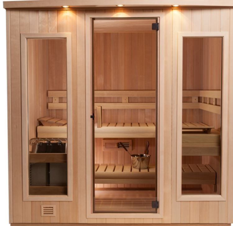 Wooden sauna with glass door and windows. Inside, a bench, heater, and bucket visible.