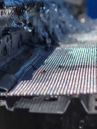 Water flows across a metal gutter with a screen.