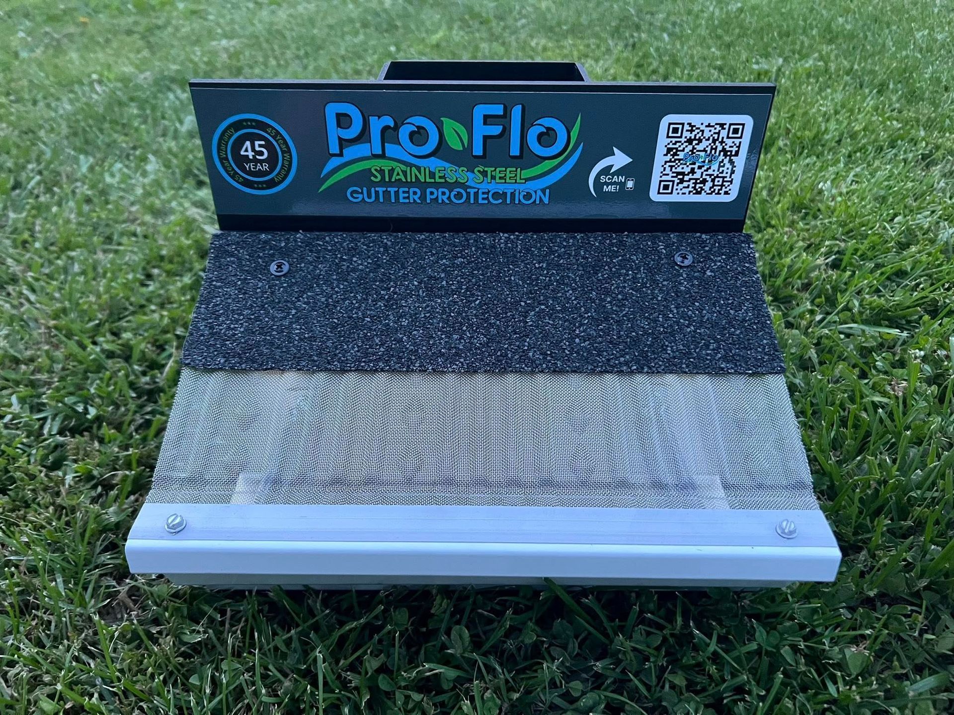 ProFlo brand gutter guard, green and silver, on grass.