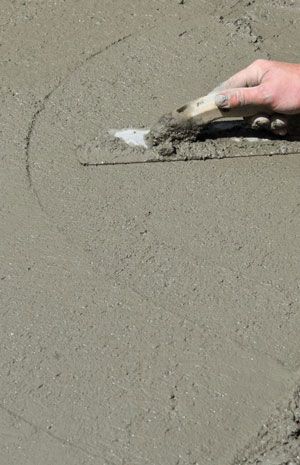 A plastering trowel flatting a cement.