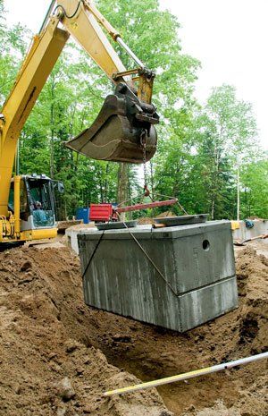An excavator installing a septic tank.