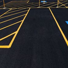 a parking lot with yellow lines and a blue handicap sign