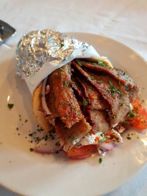A close up of a gyro on a white plate.