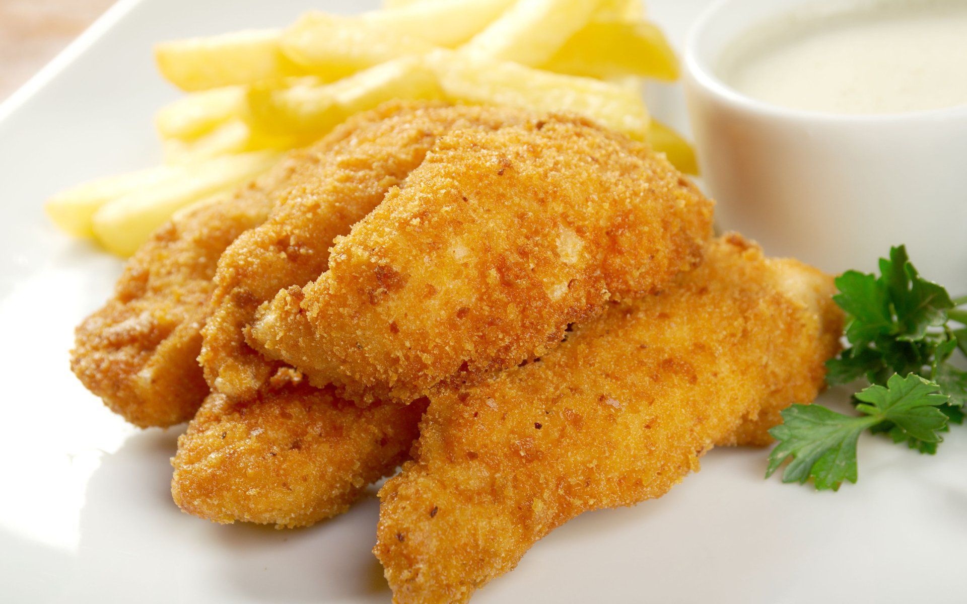 A white plate topped with fried chicken and french fries.