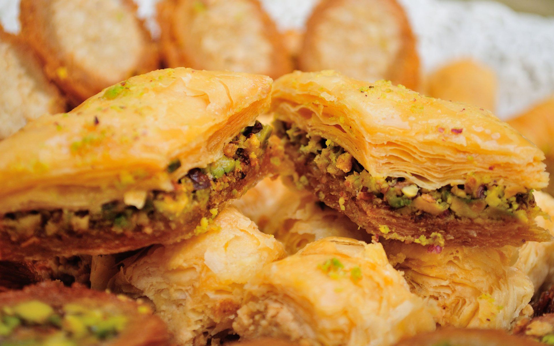 A close up of a baklava with pistachios on a table.