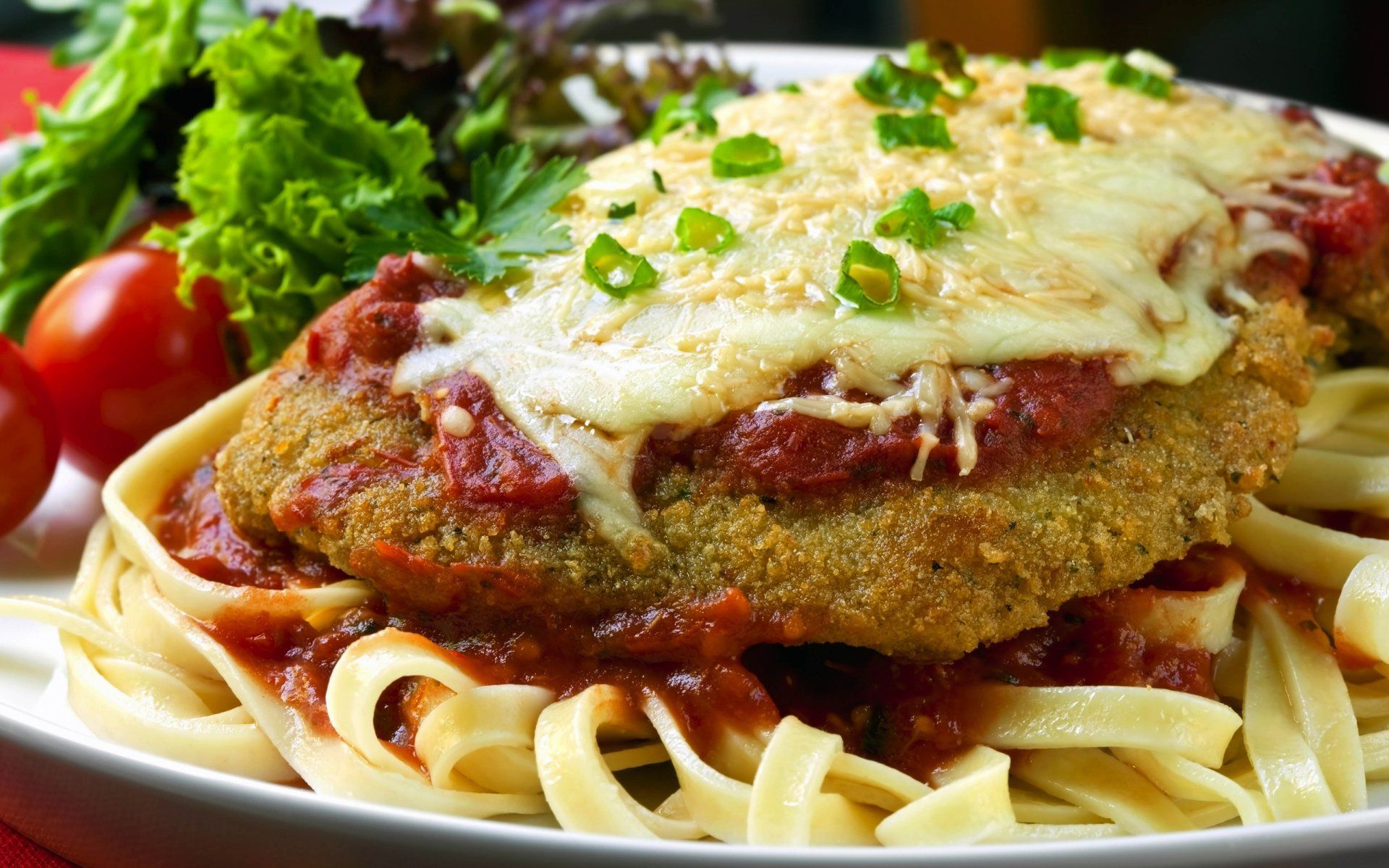 A white plate topped with noodles, meat, and sauce.