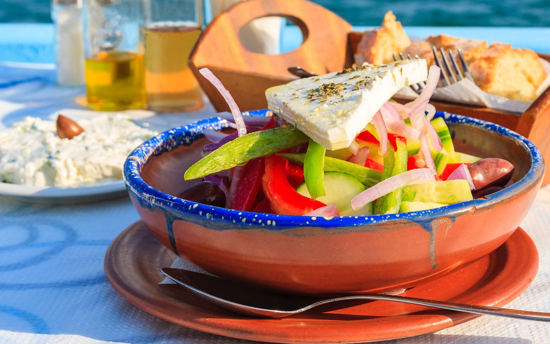 A bowl of food with a spoon in it is on a plate on a table.
