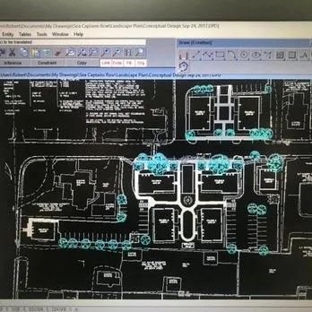Black CAD floor plan on a computer screen with white lines and blue highlights, showing multiple building rooms and corridors