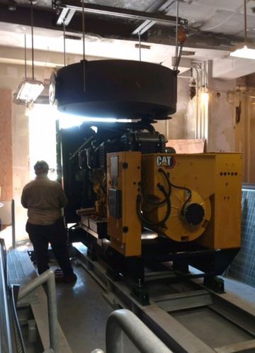 A man is standing next to a yellow CAT machine