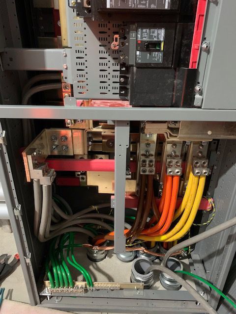 The inside of a electrical box with a breaker and a bunch of wires