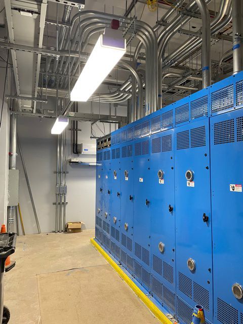 A room with a lot of blue cabinets and pipes