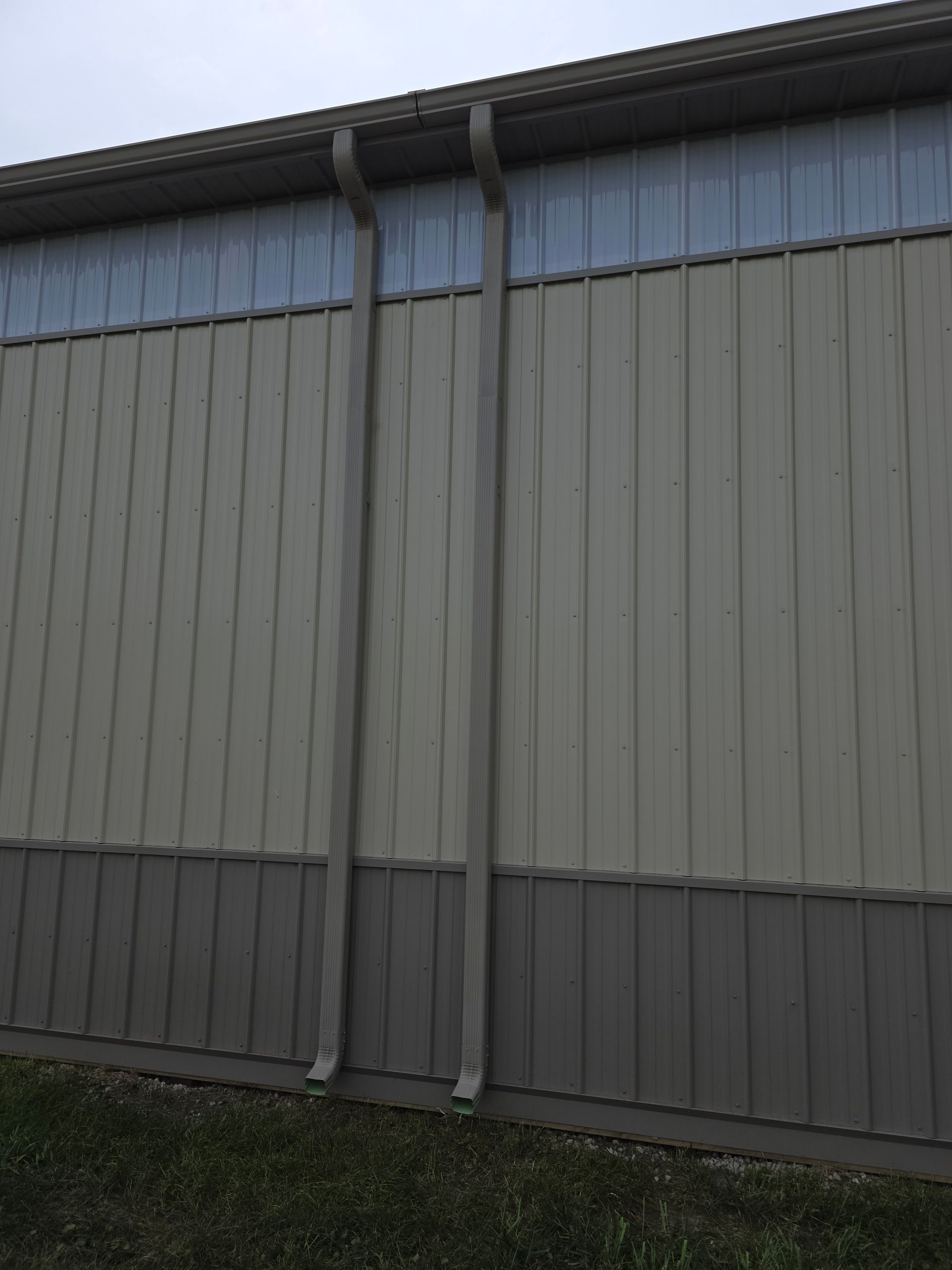 Exterior wall of a building with two downspouts.