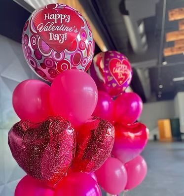 A bunch of pink balloons with one that says happy valentine 's day