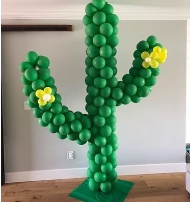 A cactus made out of green balloons with yellow flowers