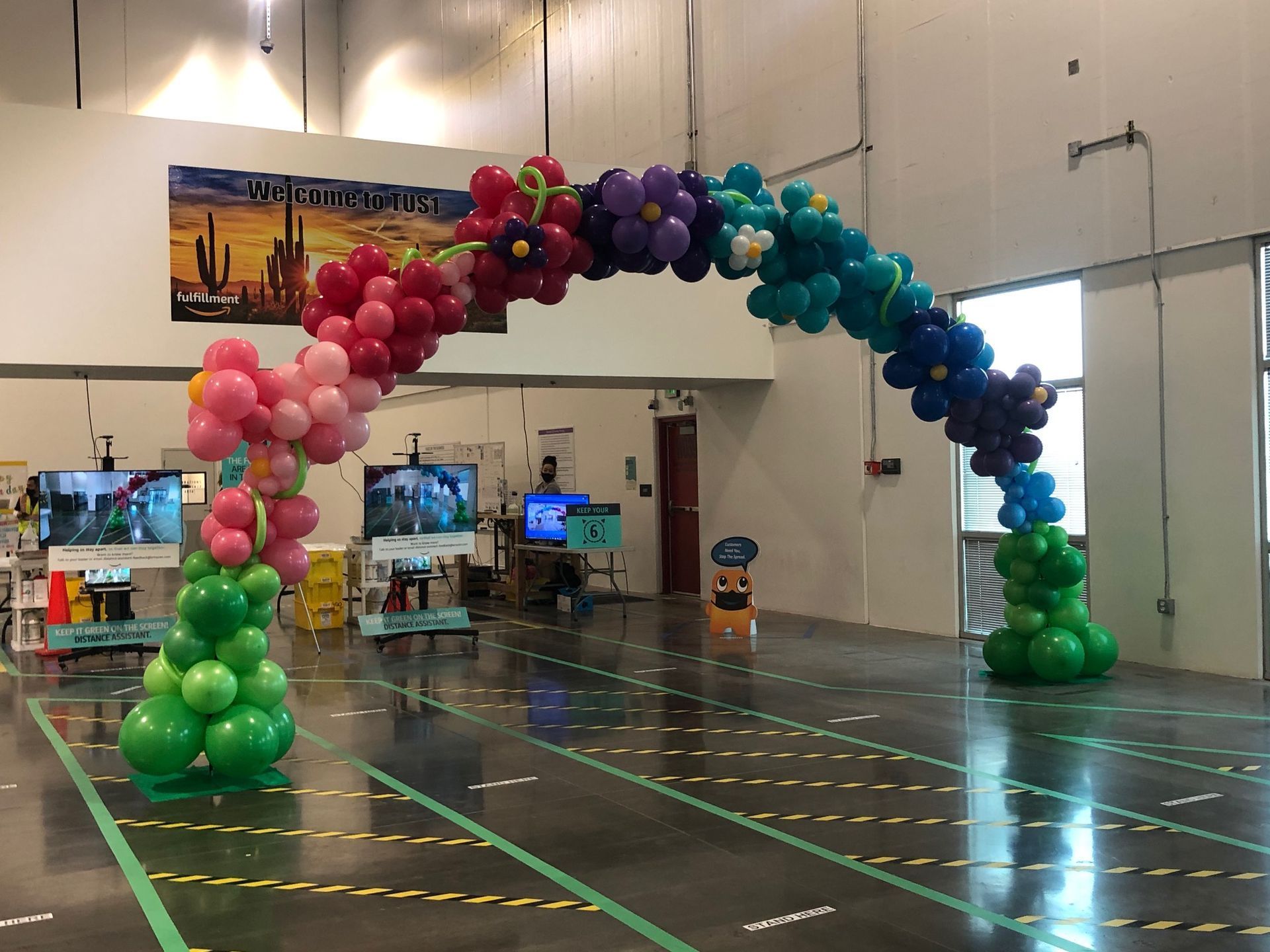 A large room with a rainbow of balloons in it