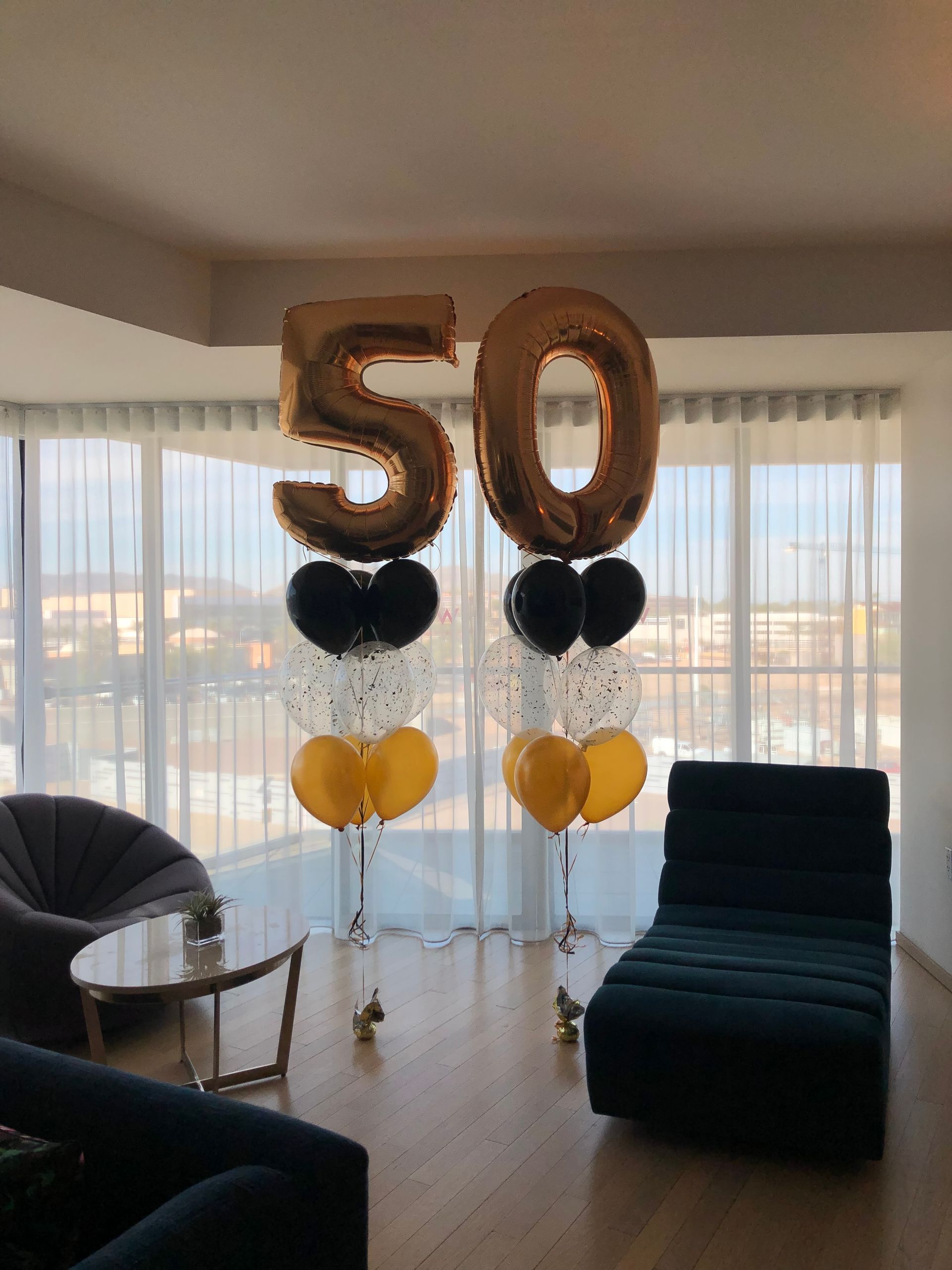 A living room with balloons in the shape of the number 50