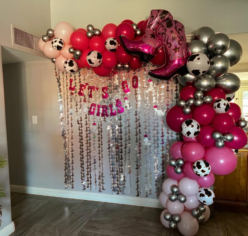 A wall with balloons and a sign that says 