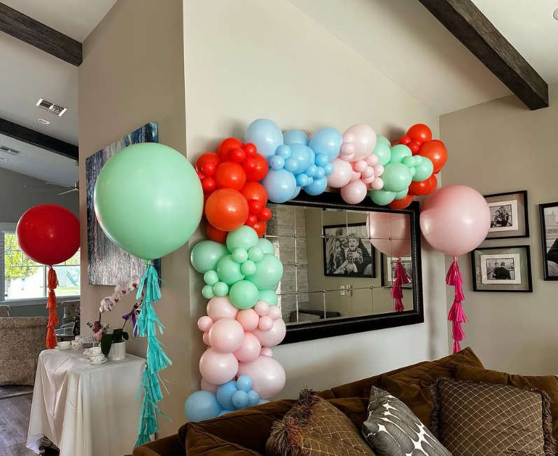 A living room decorated with balloons and a mirror