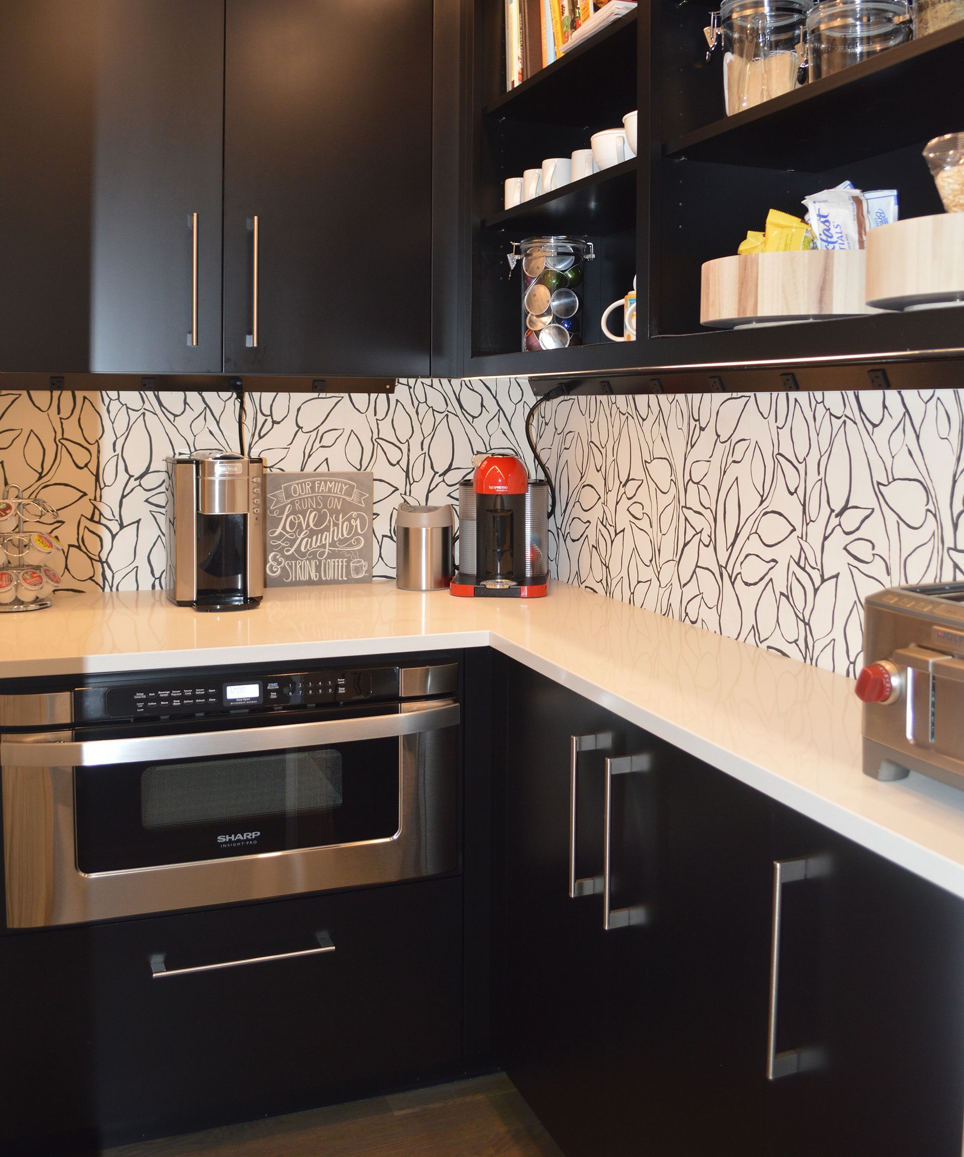 A kitchen with black cabinets and stainless steel appliances.