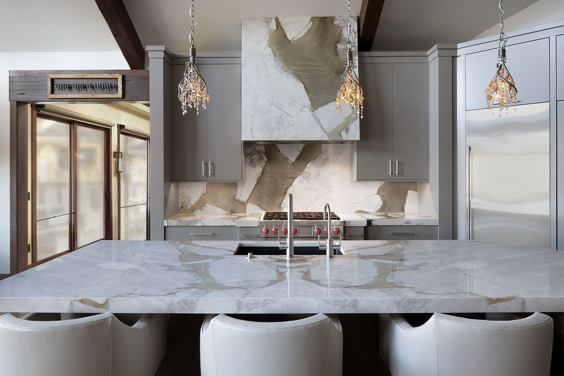 A kitchen with a large island and a stove top oven.