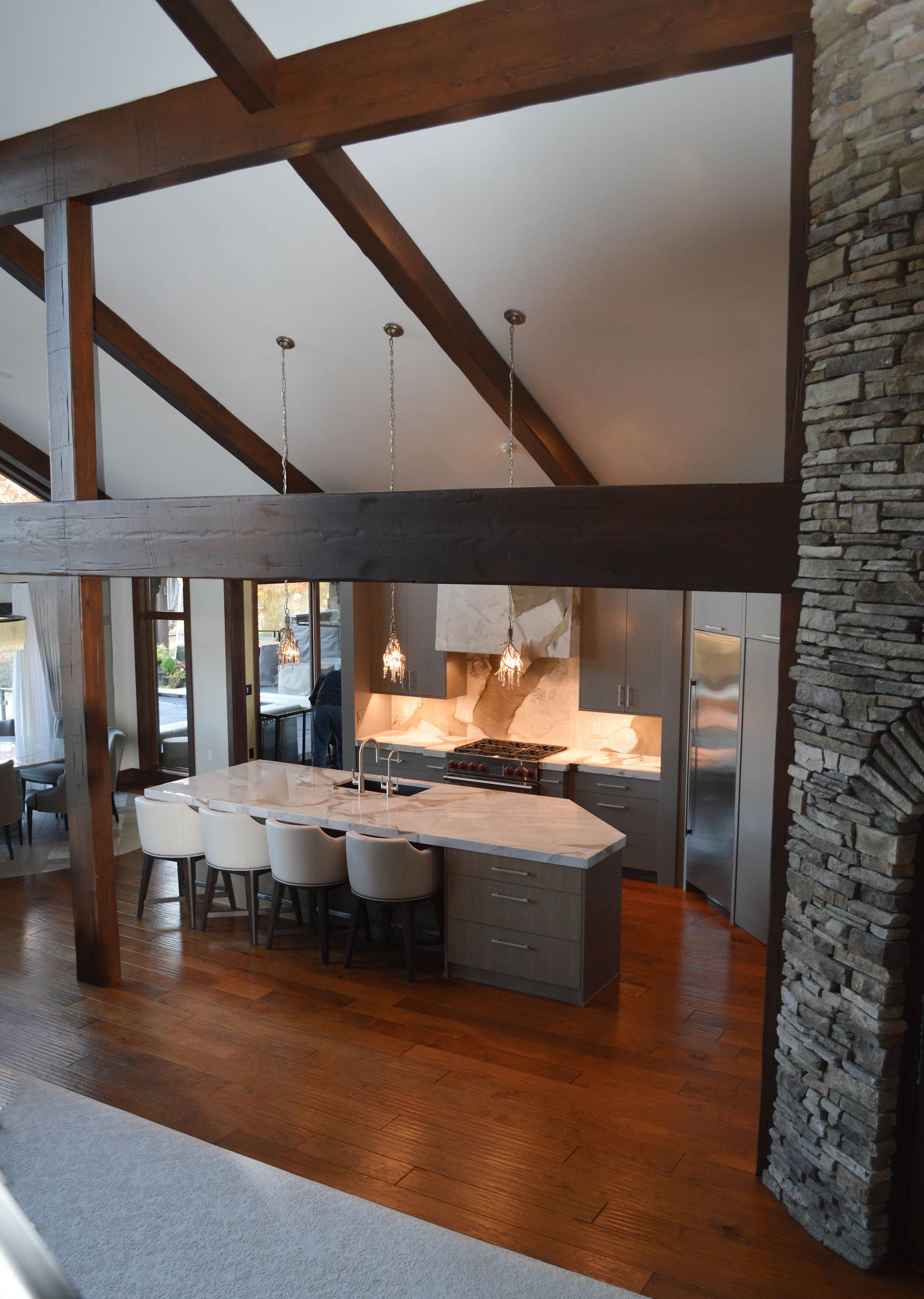 A kitchen with a large island and a stone fireplace.