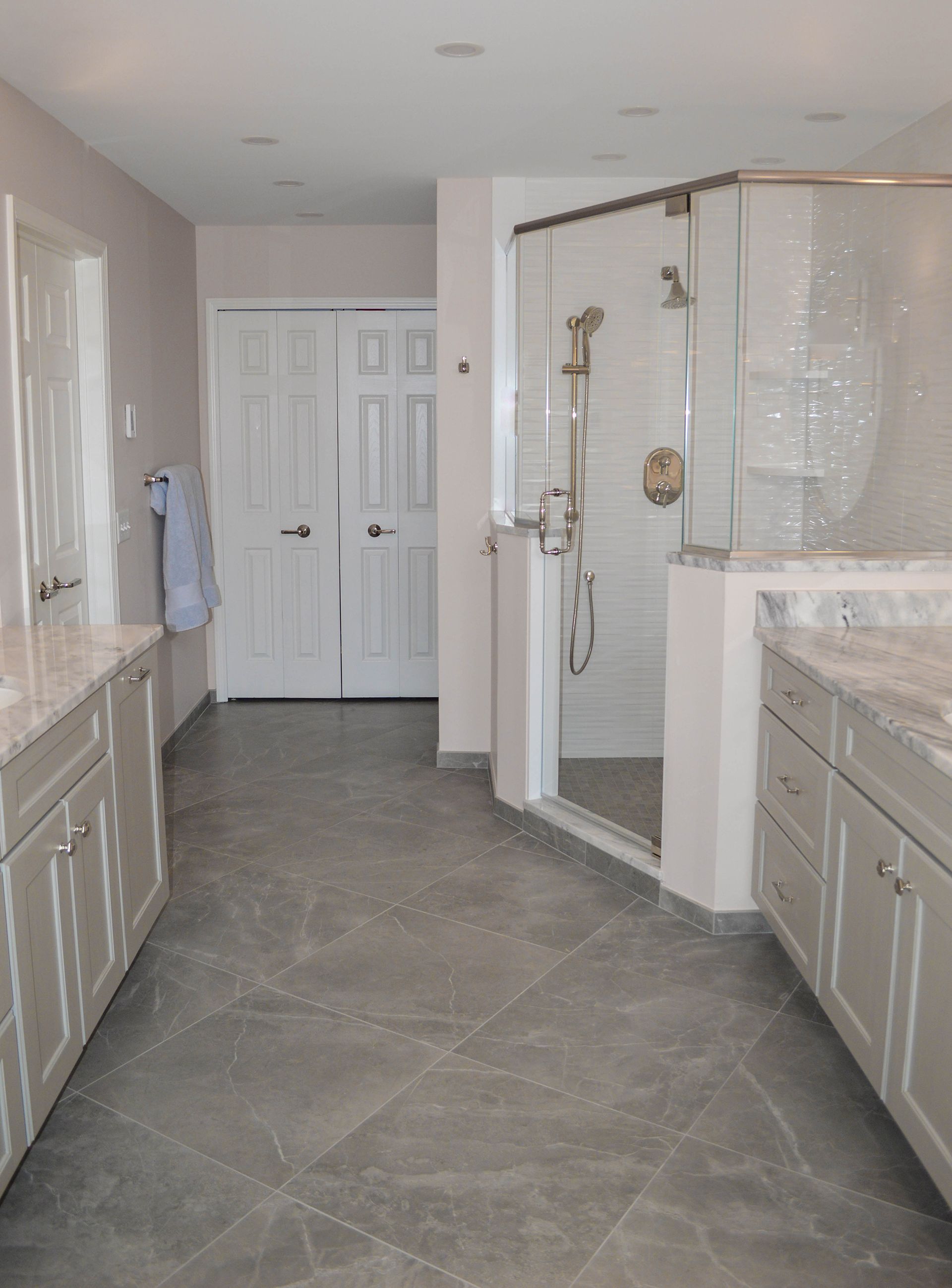 A bathroom with a walk in shower and two sinks.