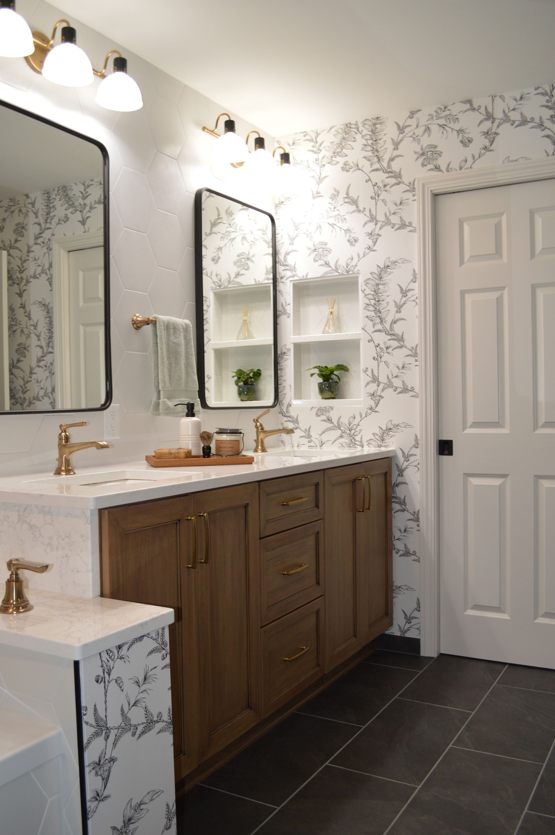 A bathroom with two sinks, two mirrors, and a door.