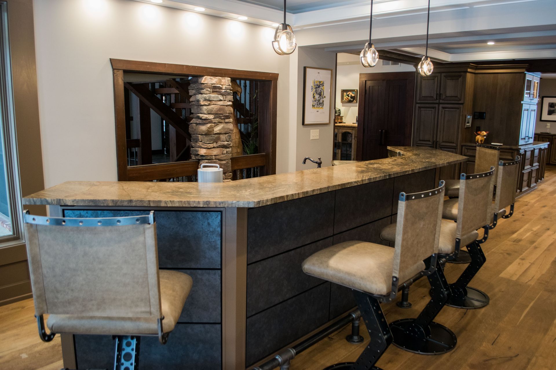 A kitchen with a bar and chairs in it