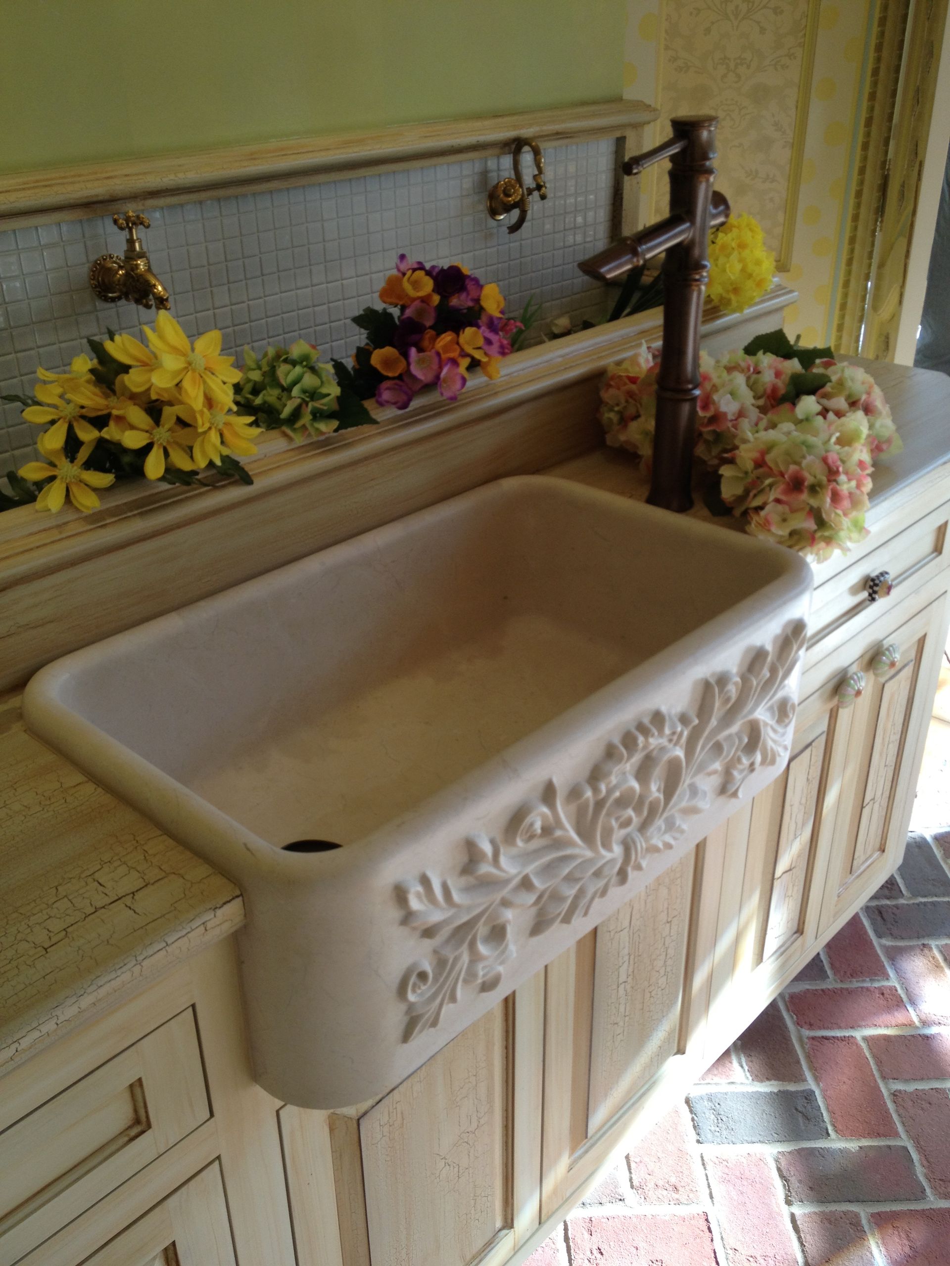 A kitchen sink with flowers on top of it