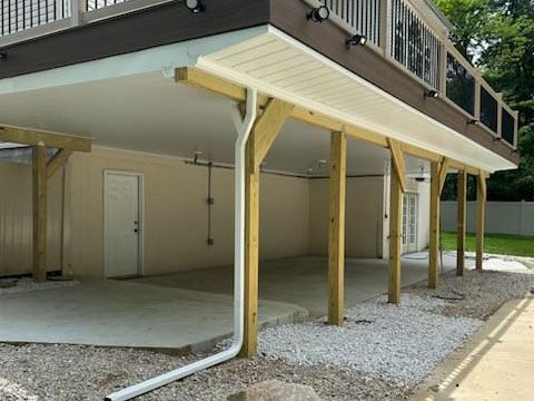A carport under the deck of a house.